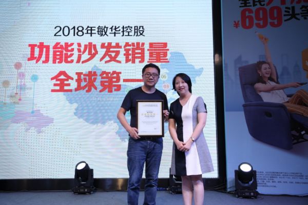 ▲欧睿国际穆愔（右一）为敏华控股颁发“2018年功能沙发销量全球第一”市场地位认证函，敏华控股大中华区总经理罗庭树（左一）上台接受颁奖