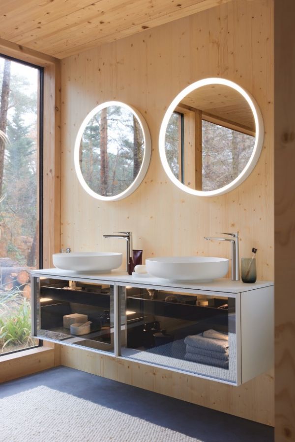 A bathroom with two round mirrors AI-generated content may be incorrect.